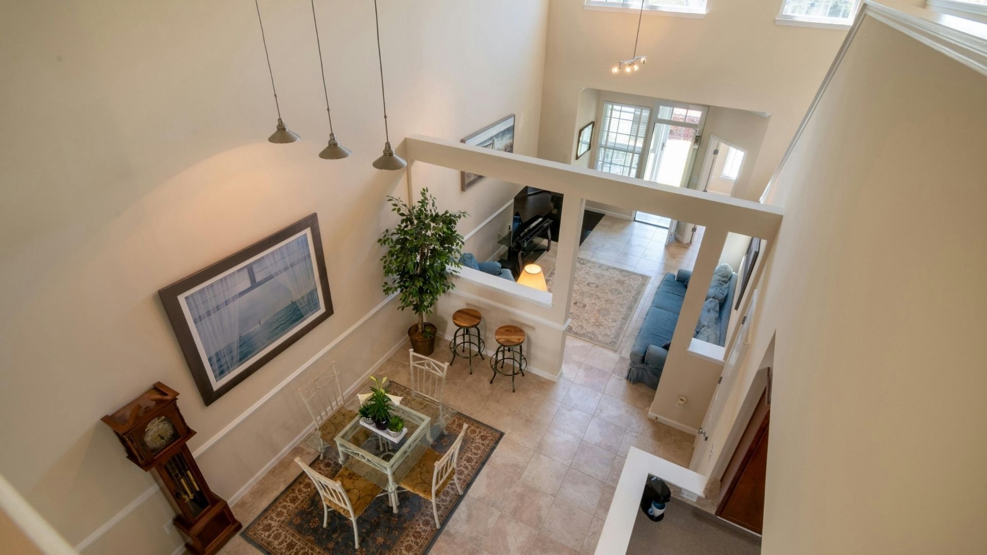 Modern home interior with loft space, pendant lights, and plants viewed from above